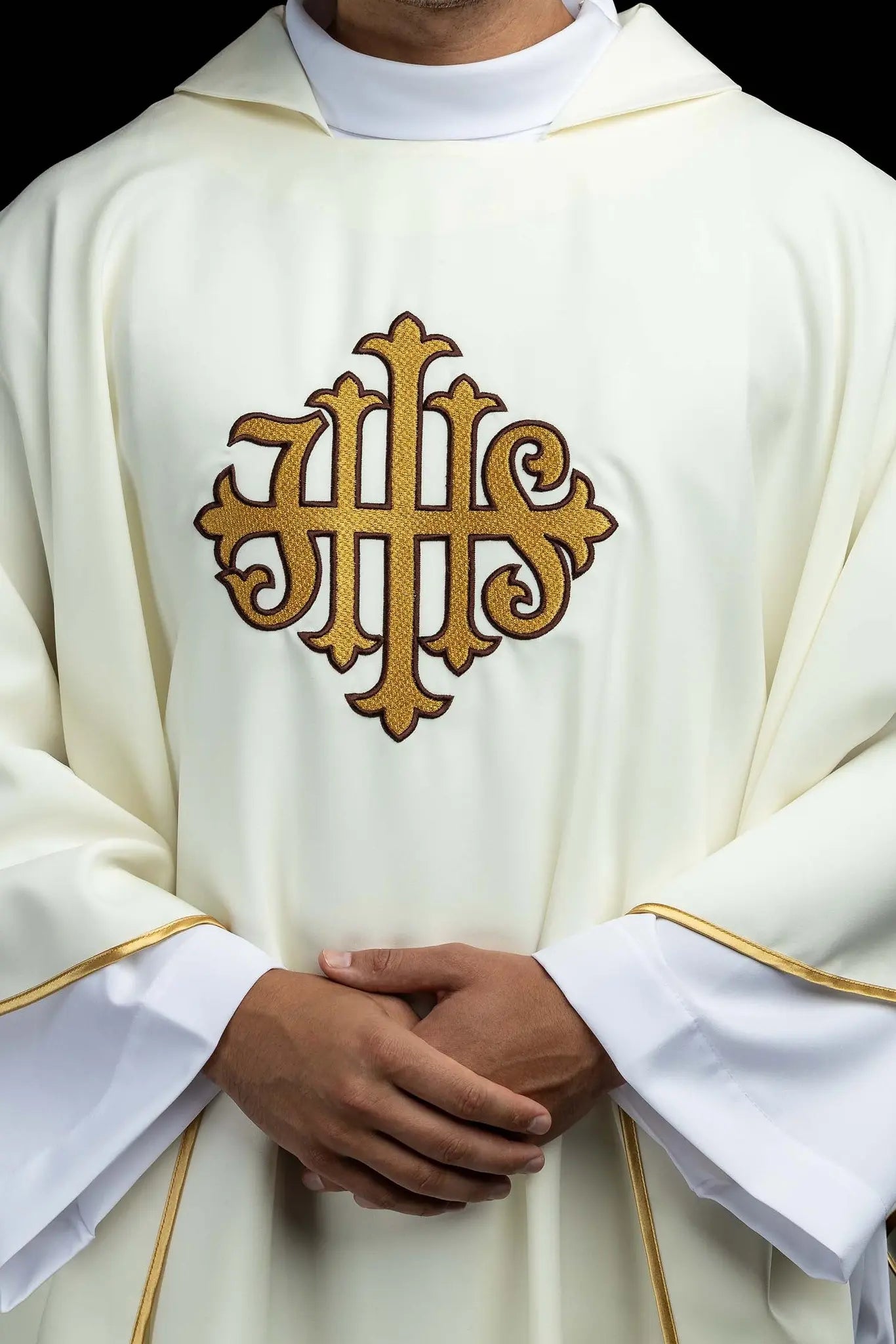 Ecru chasuble with gold IHS embroidery and gold trim, featuring a V-neck collar.