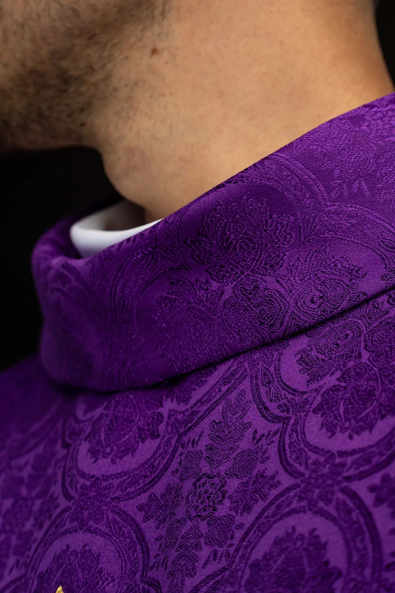 Purple chasuble with a gold embroidered cross on jacquard fabric, featuring a stand-up collar and gold trim.