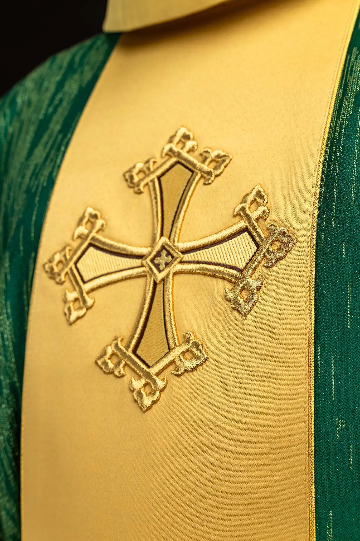 Green chasuble with a vertical gold band featuring embroidered crosses, gold trim on edges and collar, and a stand-up collar.