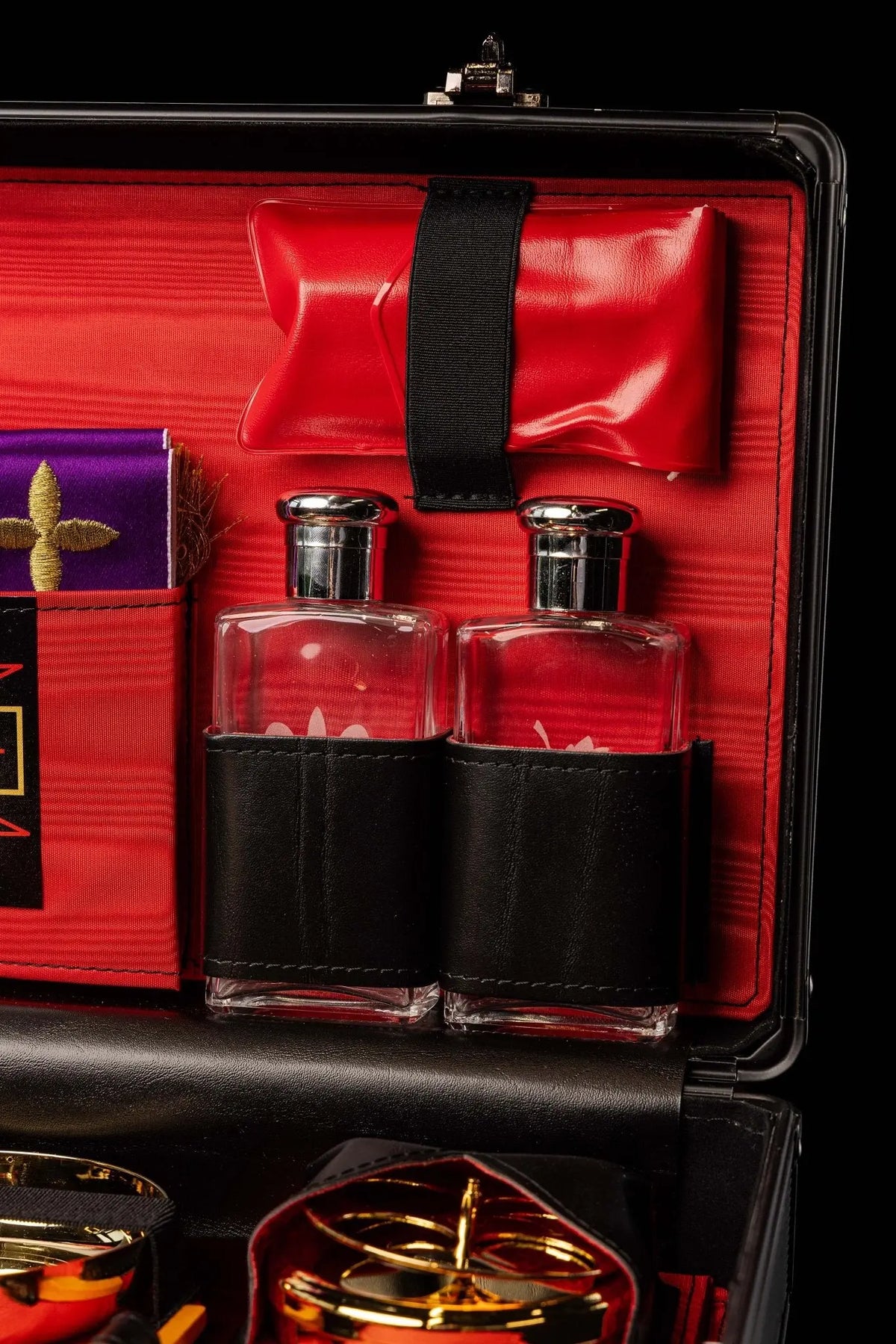 Valise-chapelle rouge, linges de calice blancs et étole violette, gros plan