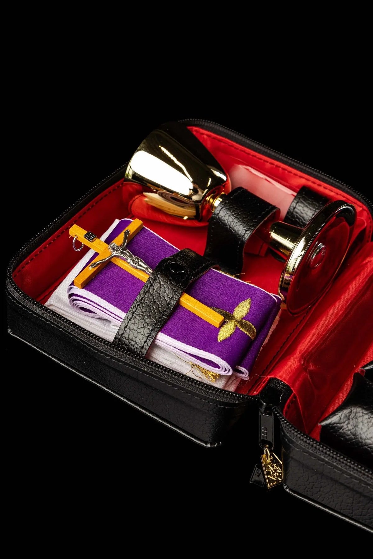 Valise de mission noire avec équipement liturgique, vue intérieure avec étole violette et croix