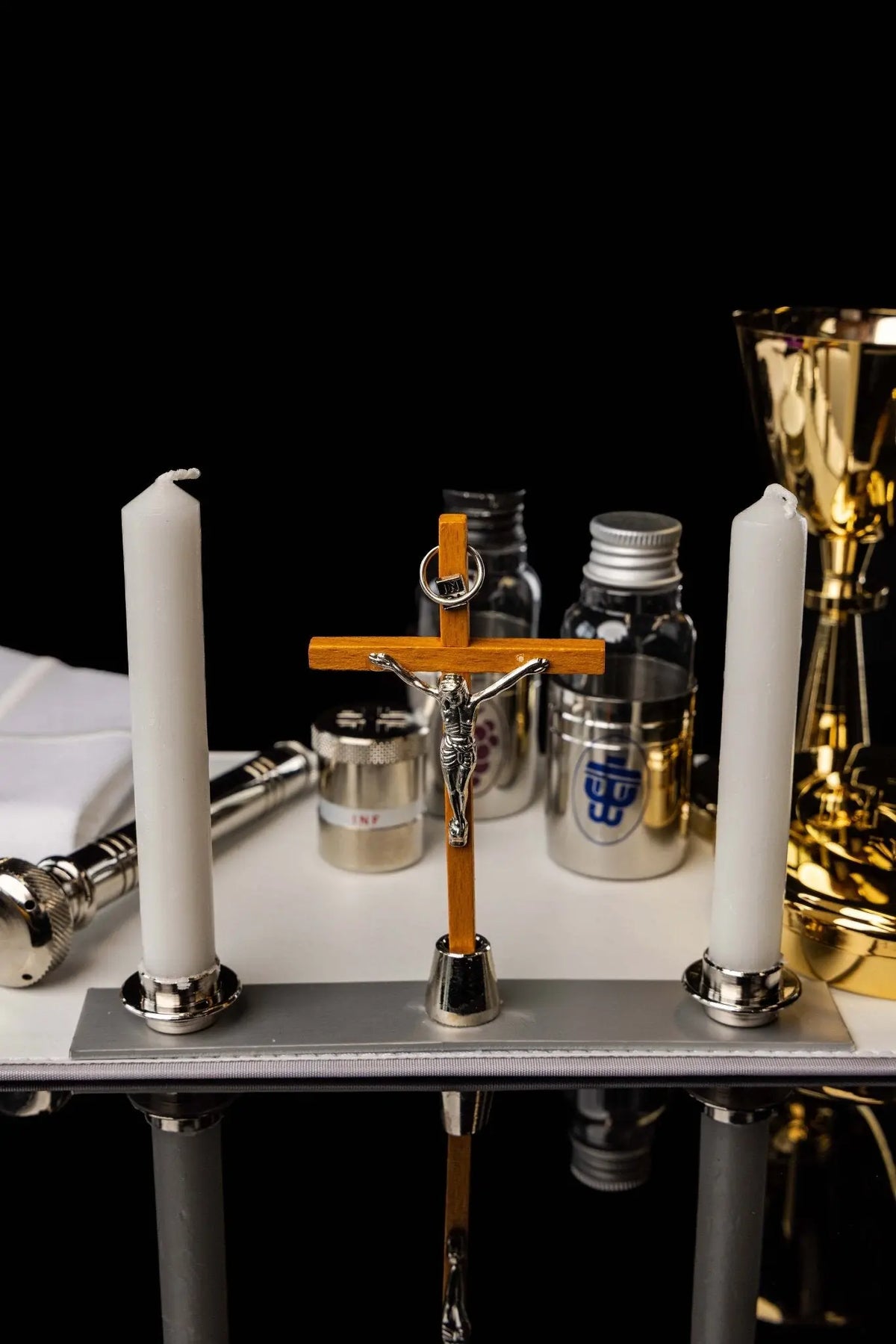 Valise noire avec équipement liturgique en aluminium, croix entre deux cierges, vue intérieure
