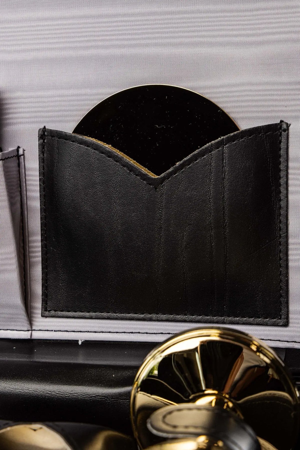 Valise liturgique, compartiment noir contenant une patène dorée, gros plan