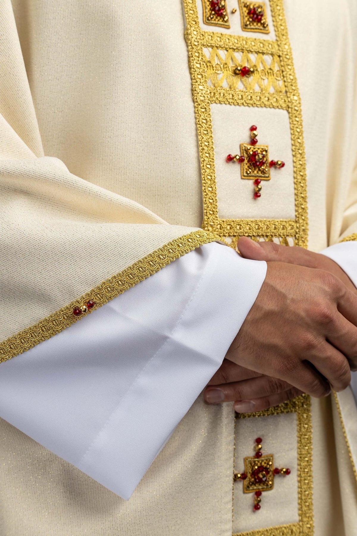 Chasuble écru ornée de pierres naturelles, gros plan de la croix en pierres rouges