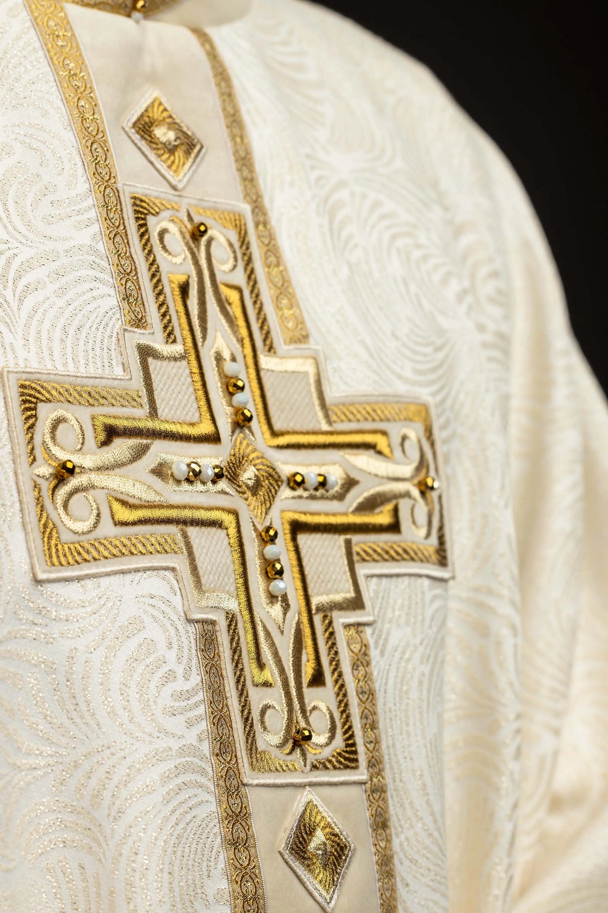 Écru chasuble avec croix brodée, gros plan de la broderie frontale