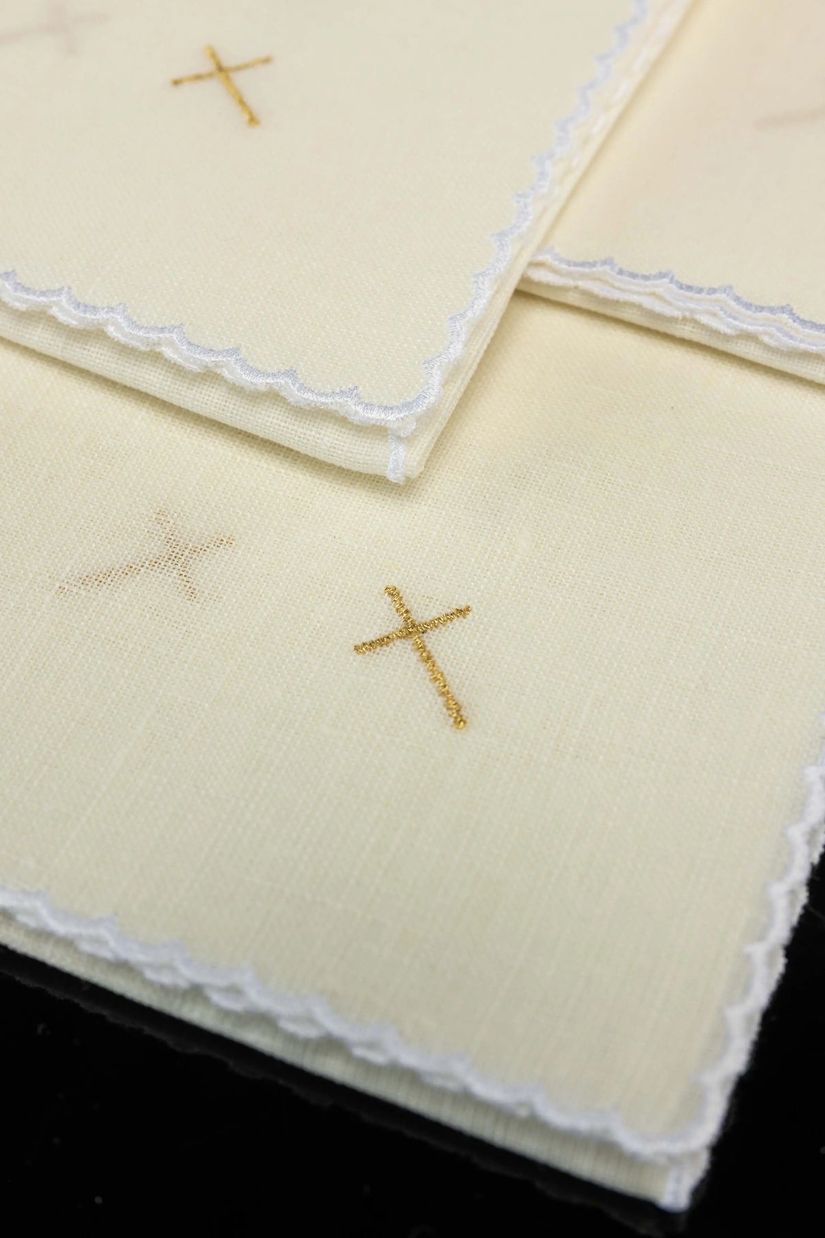 Écru corporal en lin avec croix en broderie dorée, gros plan sur la bordure