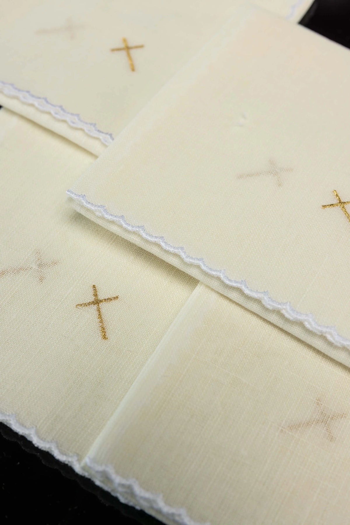 Écru corporal en lin avec croix en broderie dorée, vue rapprochée des corporaux superposés