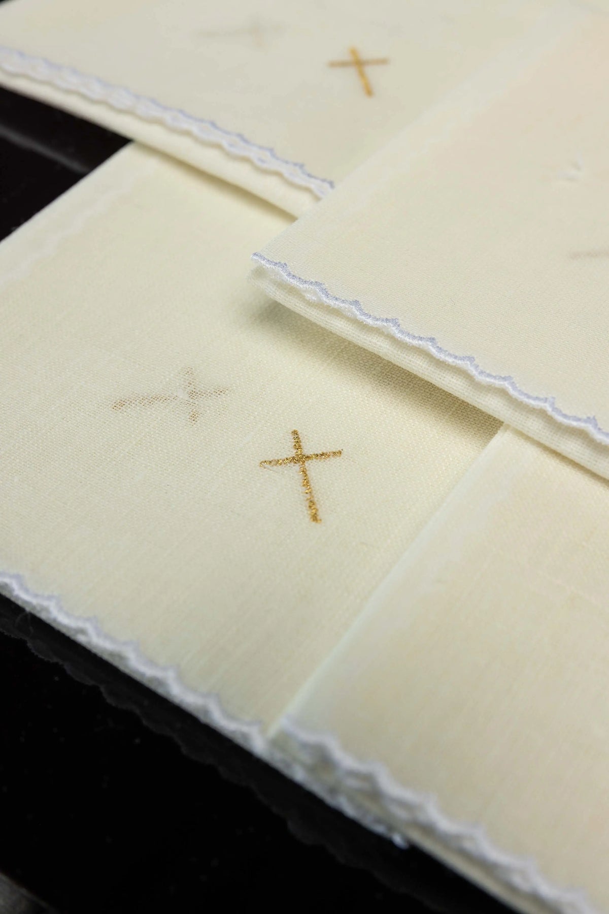 Écru corporal en lin avec croix en broderie dorée, gros plan sur le tissage