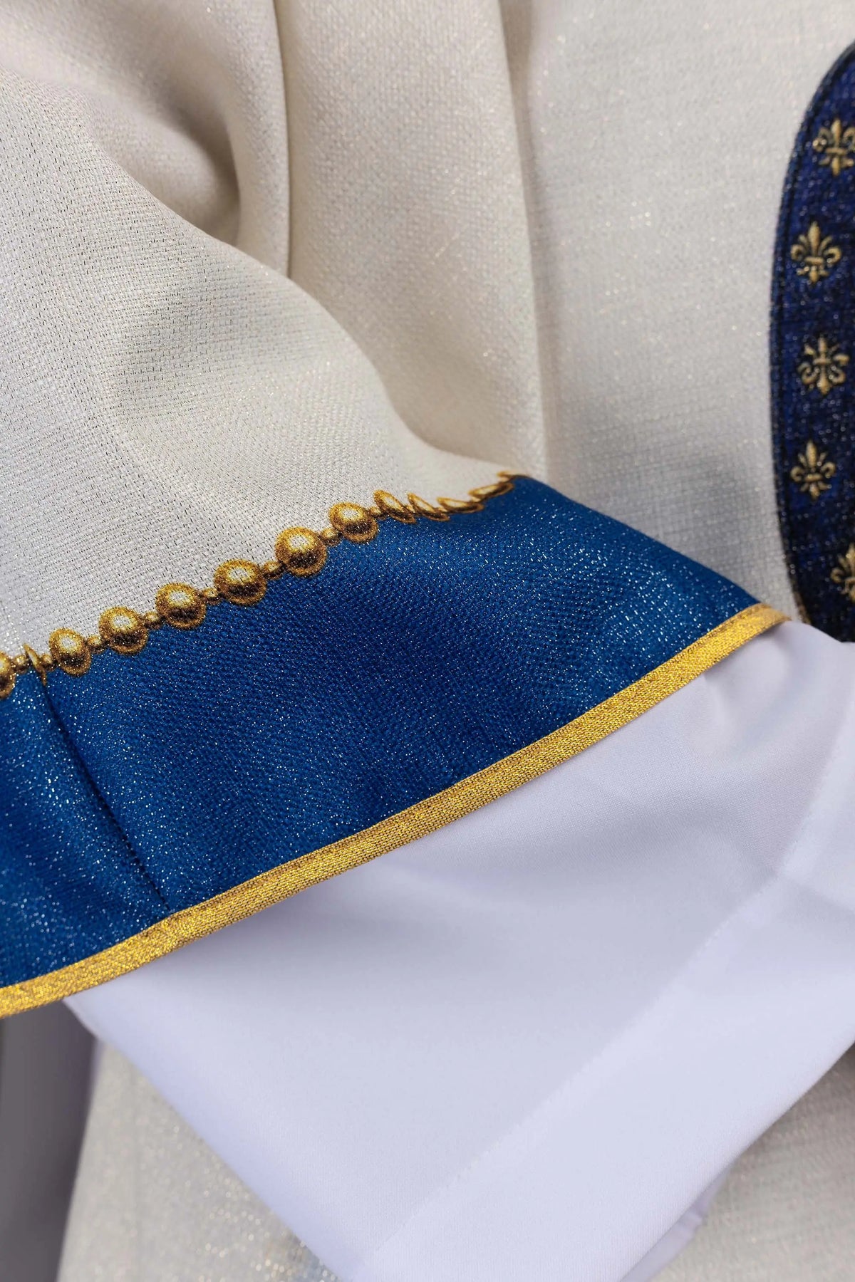 Écrue chasuble avec bordure bleue et galon doré, gros plan