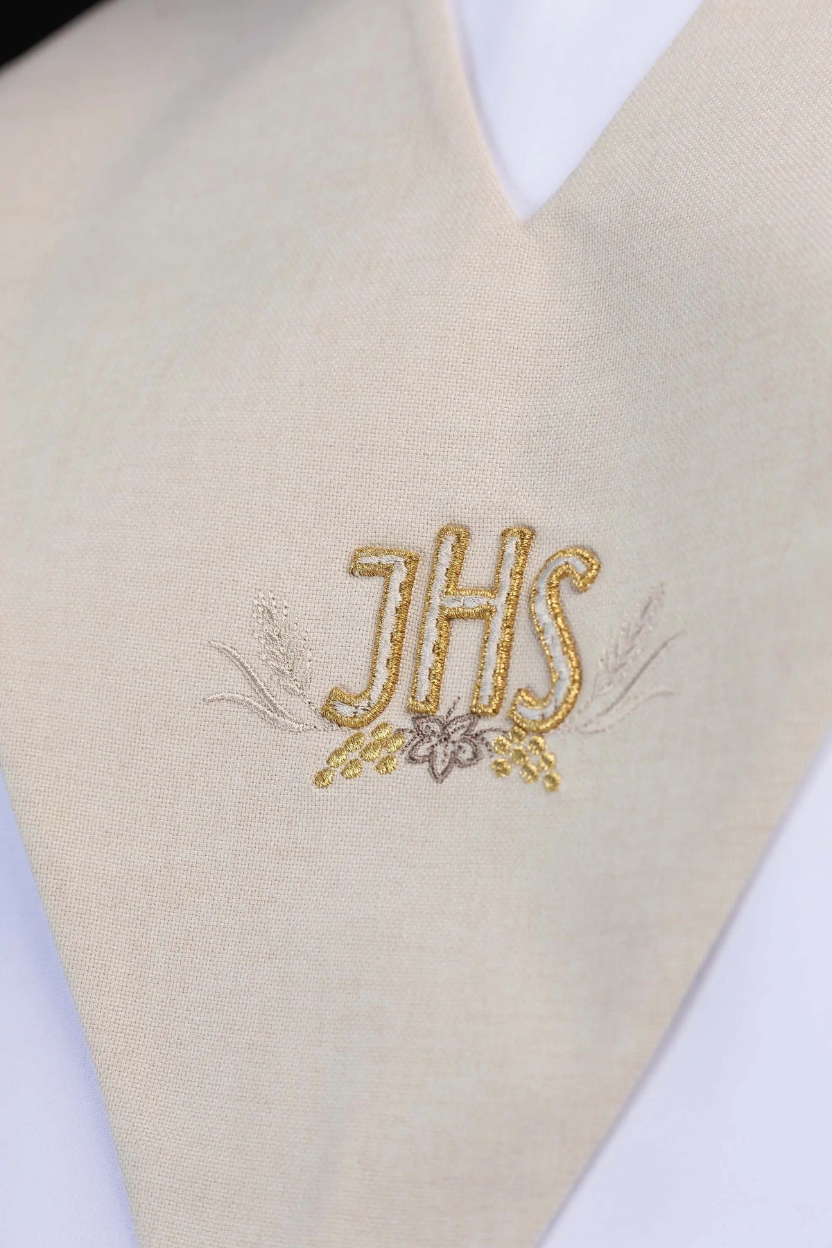 Écharpe de lecteur écrue avec broderie IHS dorée, gros plan sur le motif