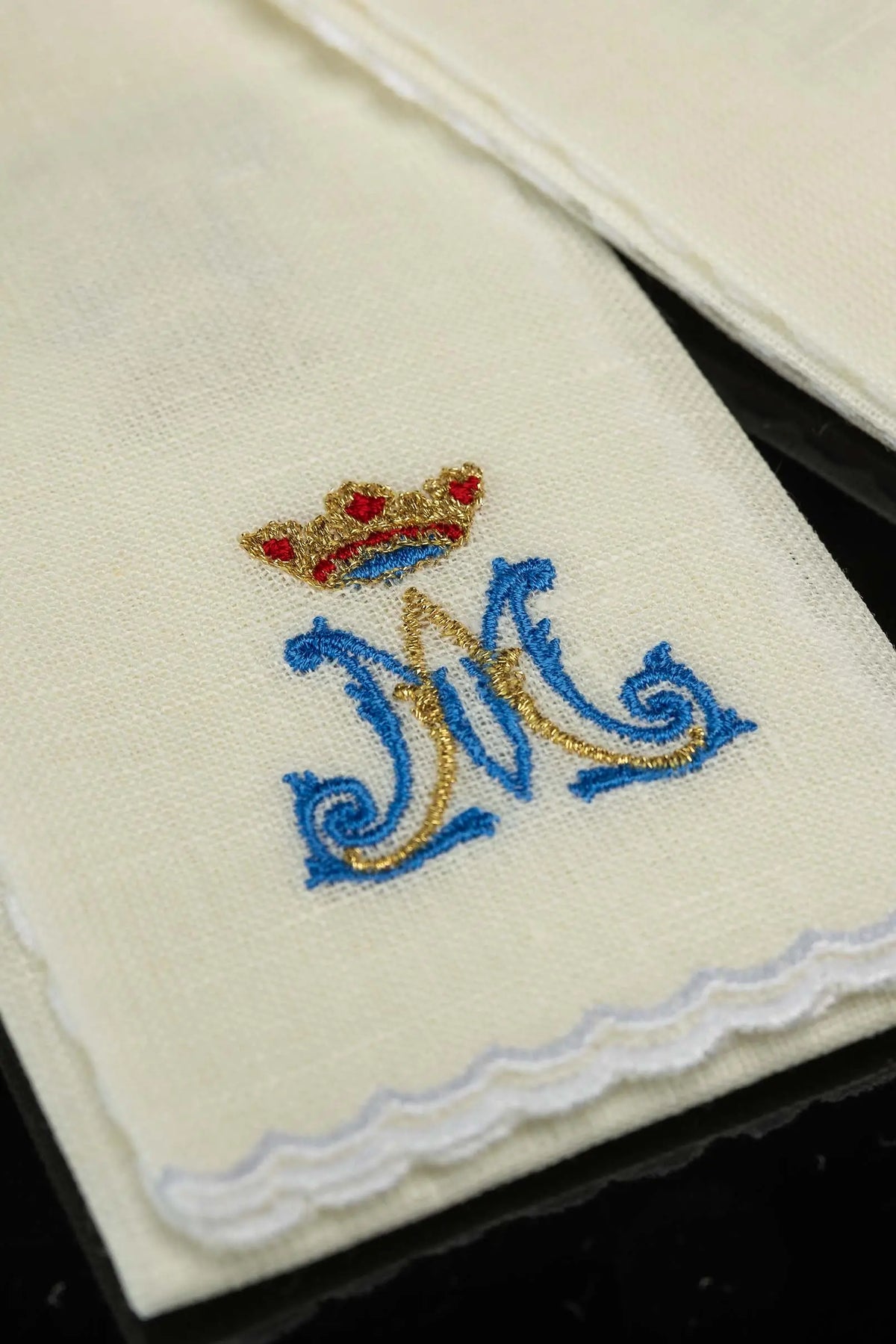 Écru purificatoire en lin avec un monogramme marial et bord festonné, gros plan