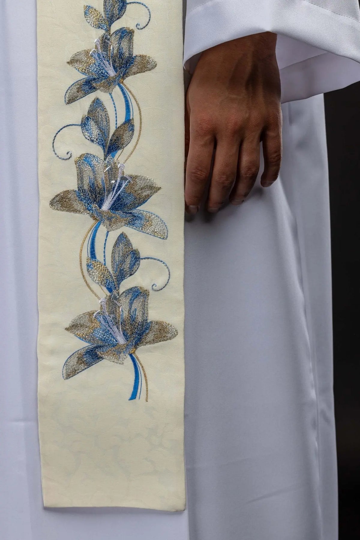 Écru étole avec fleurs bleues brodées, gros plan du motif floral