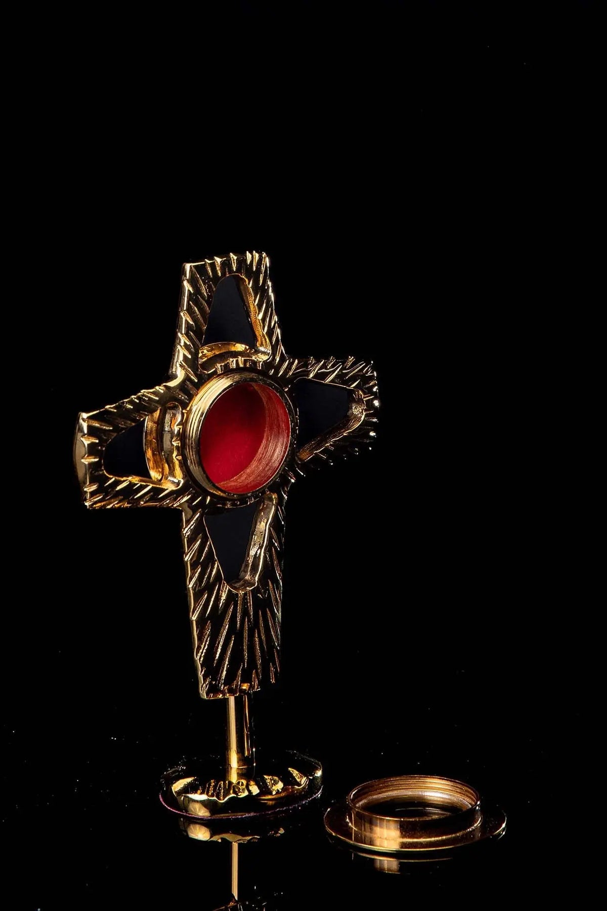 Doré reliquaire en forme de croix en laiton, ouverture rouge et support démonté, vue de trois quarts