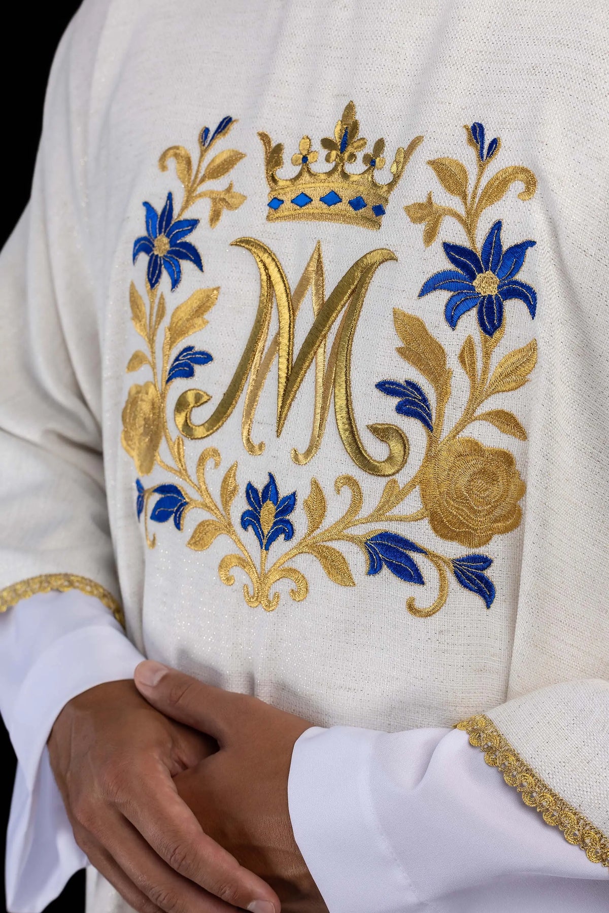 Dalmatique écrue avec monogramme « M » brodé, gros plan du motif floral