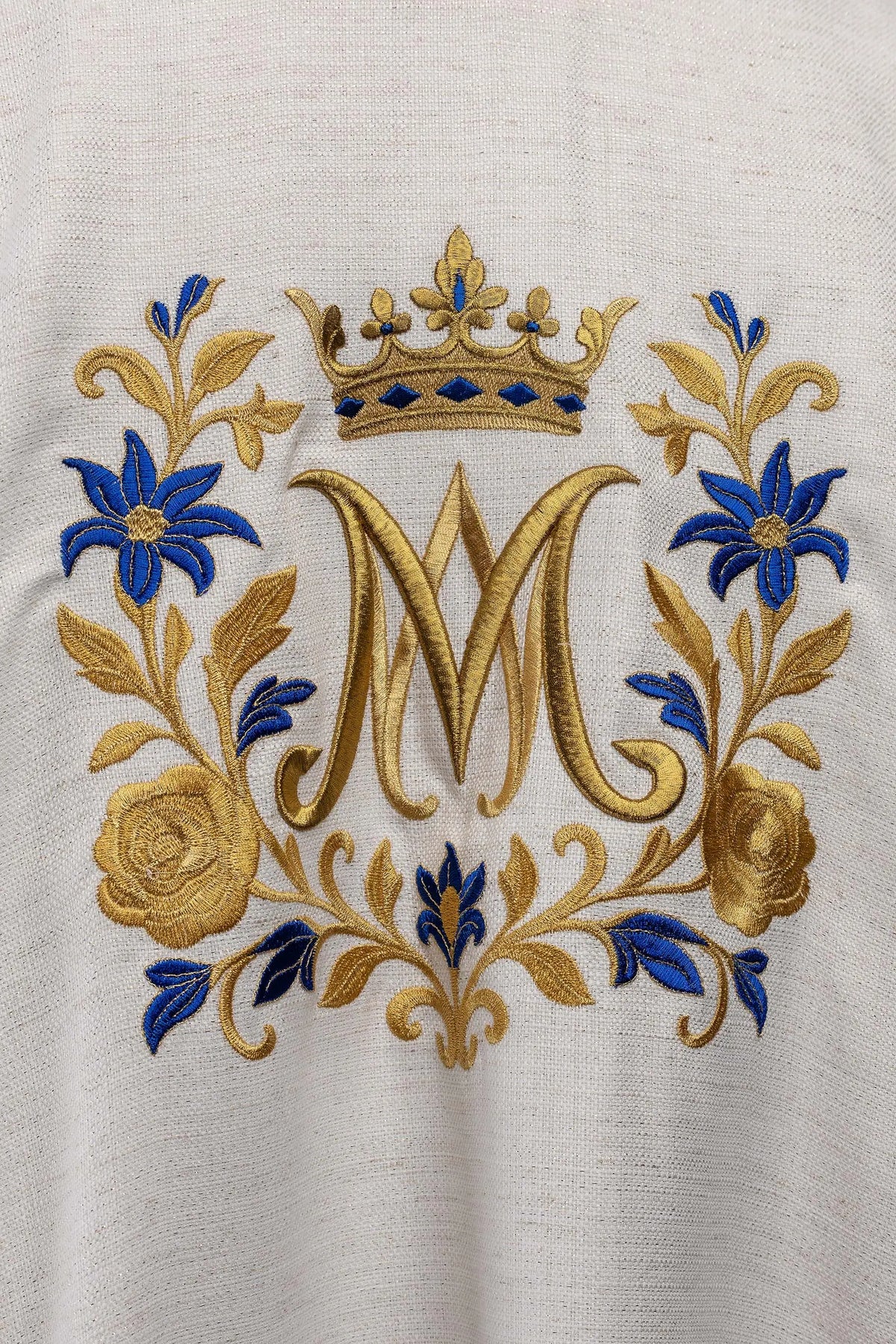 Dalmatique écrue avec monogramme « M » brodé, gros plan du monogramme et de la couronne