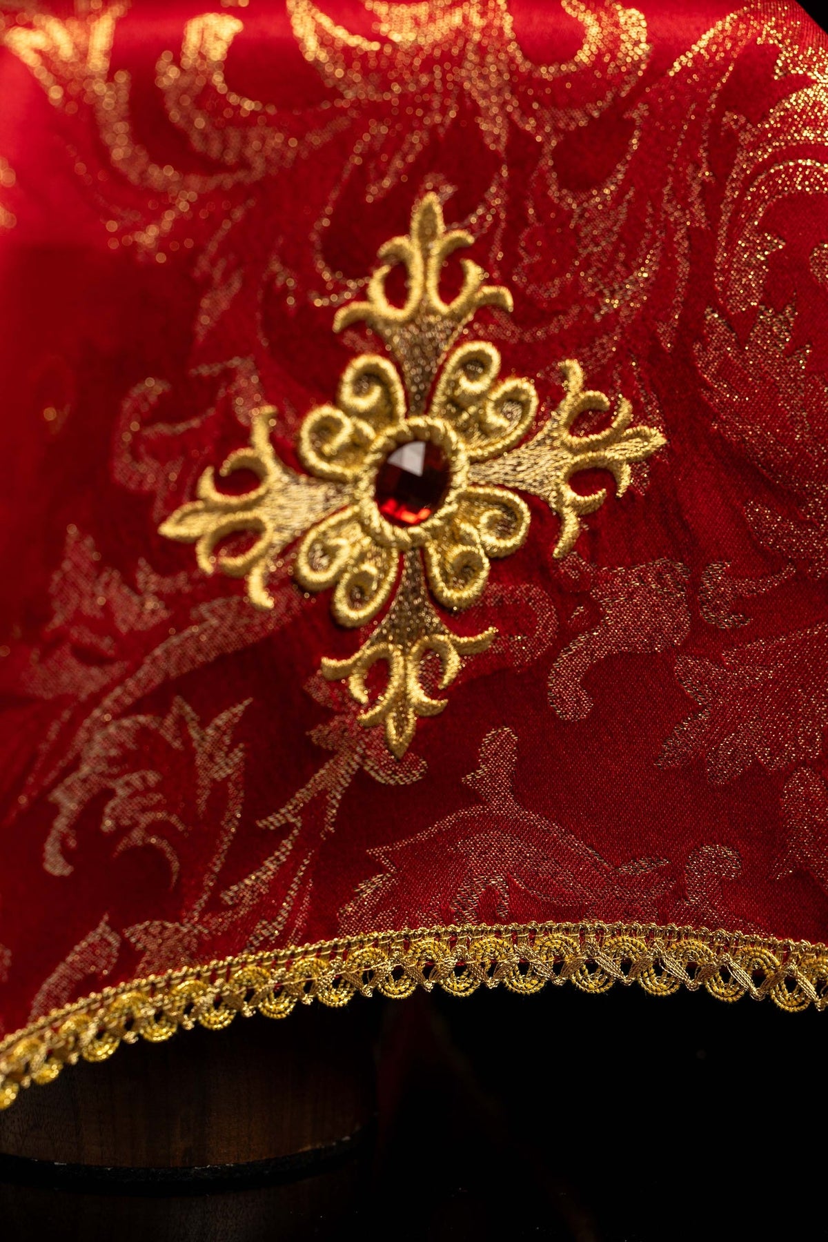 Rouge voile de calice avec croix brodée, gros plan sur la pierre