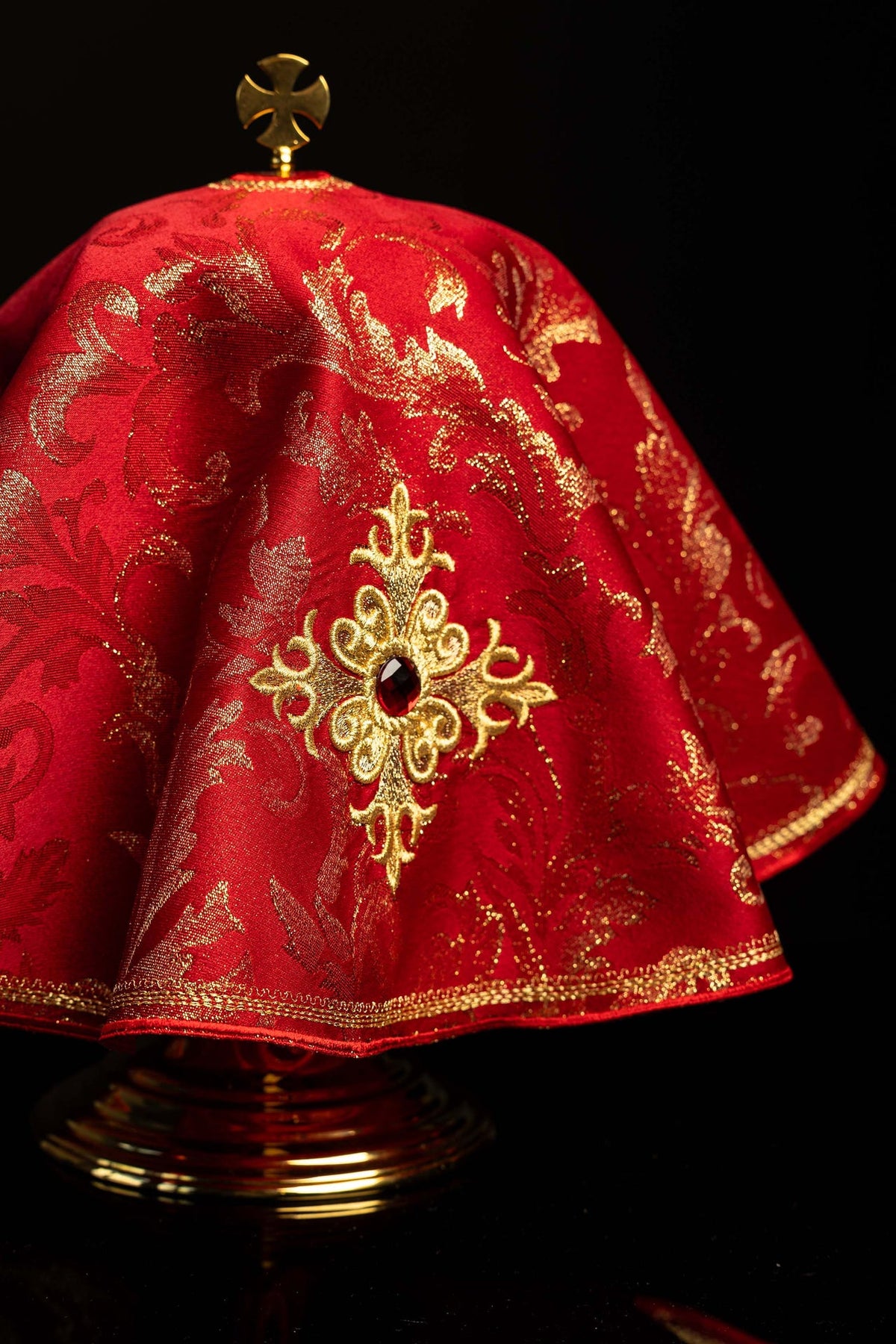 Rouge voile de ciboire brodé d'une croix dorée, vue rapprochée de côté
