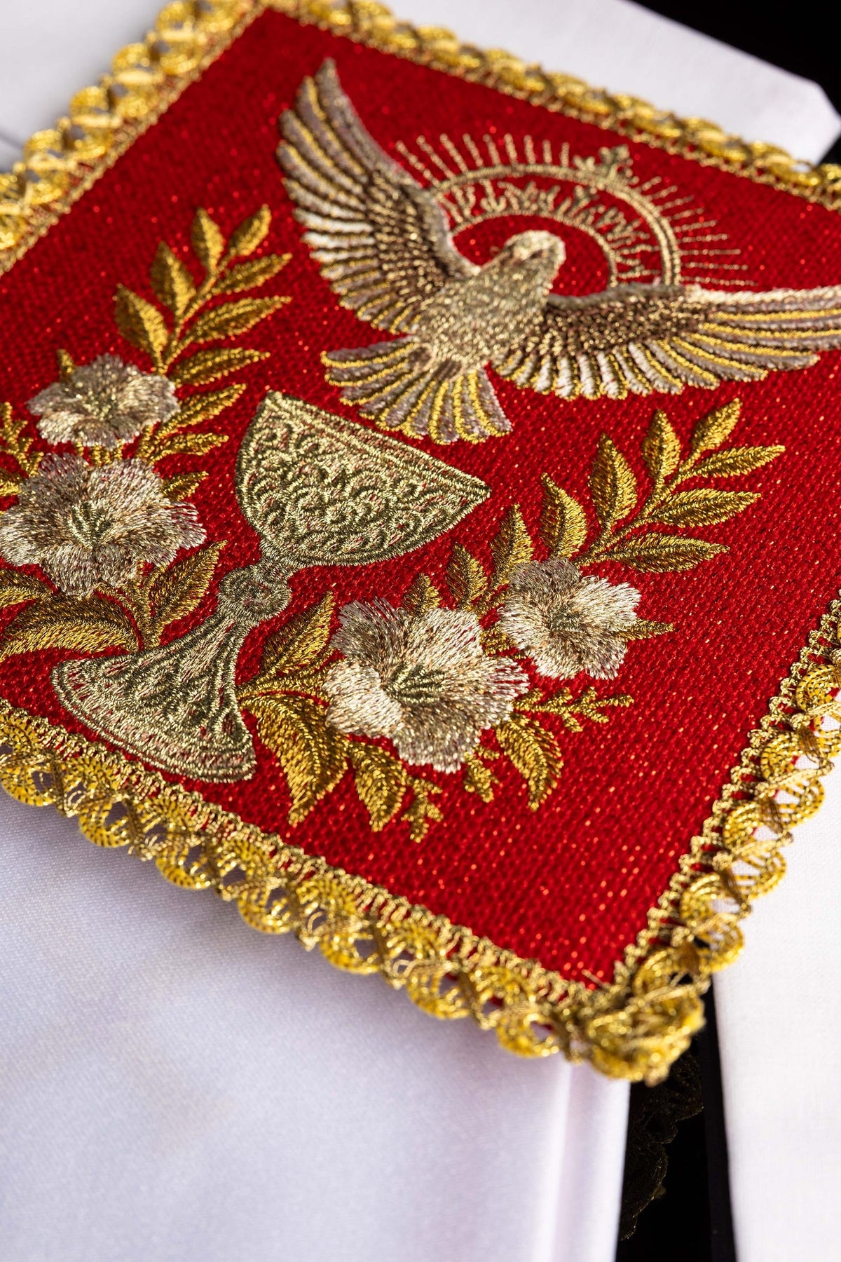 Linges de calice rouges avec colombe brodée et bordure dorée, vue rapprochée