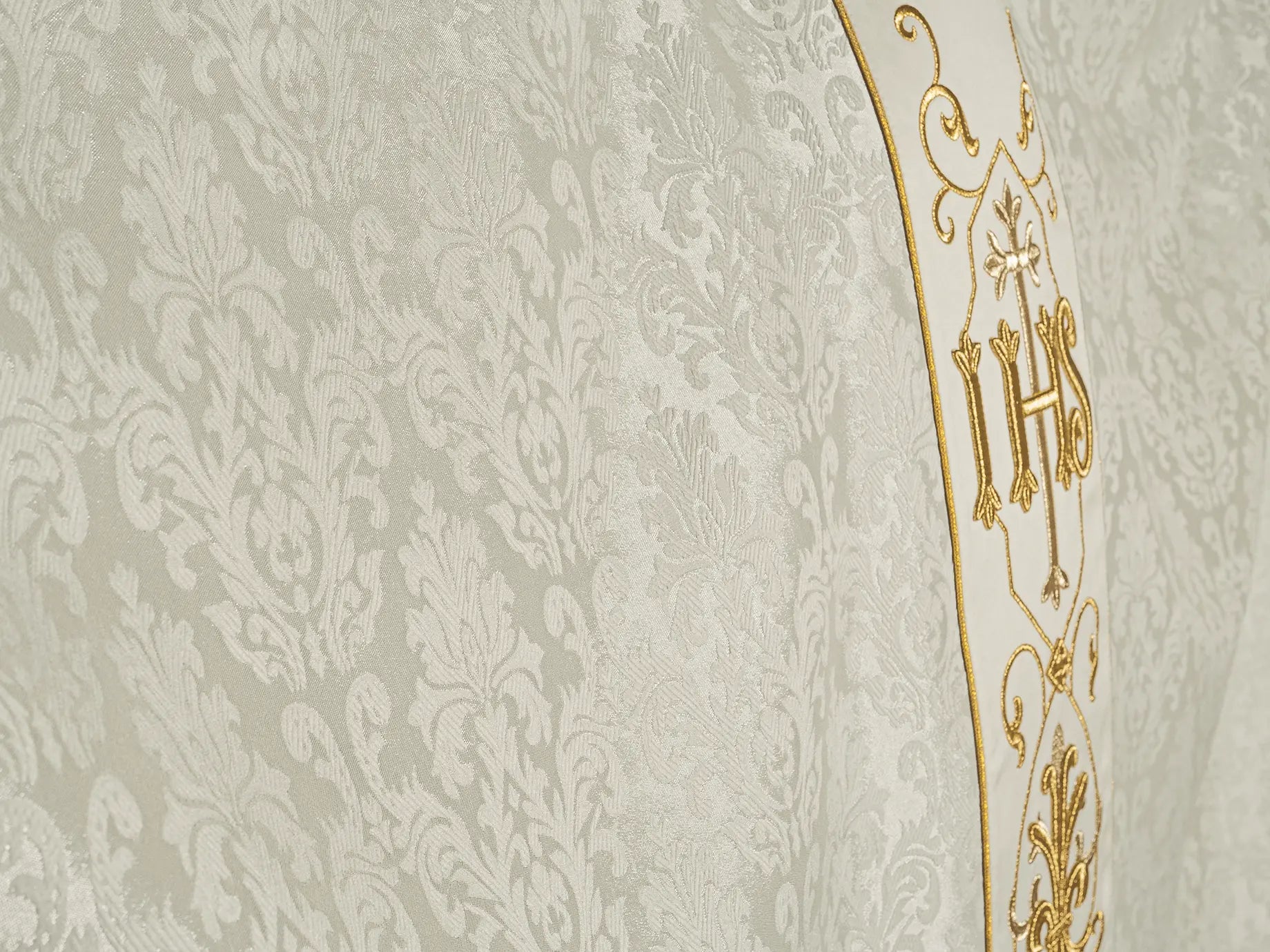 Chasuble écrue brodée sur tissu décoratif avec symbole IHS