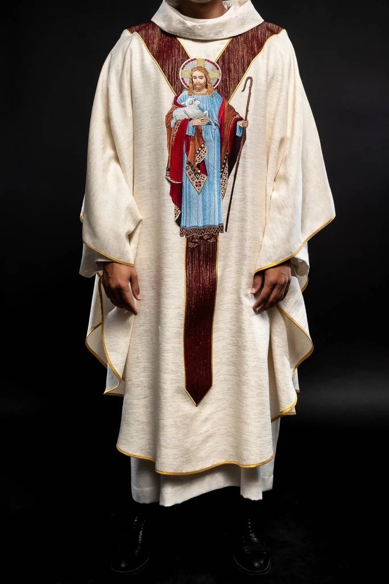 Chasuble écrue avec l'image de Jésus le Bon Pasteur avec une bande décorative bordeaux