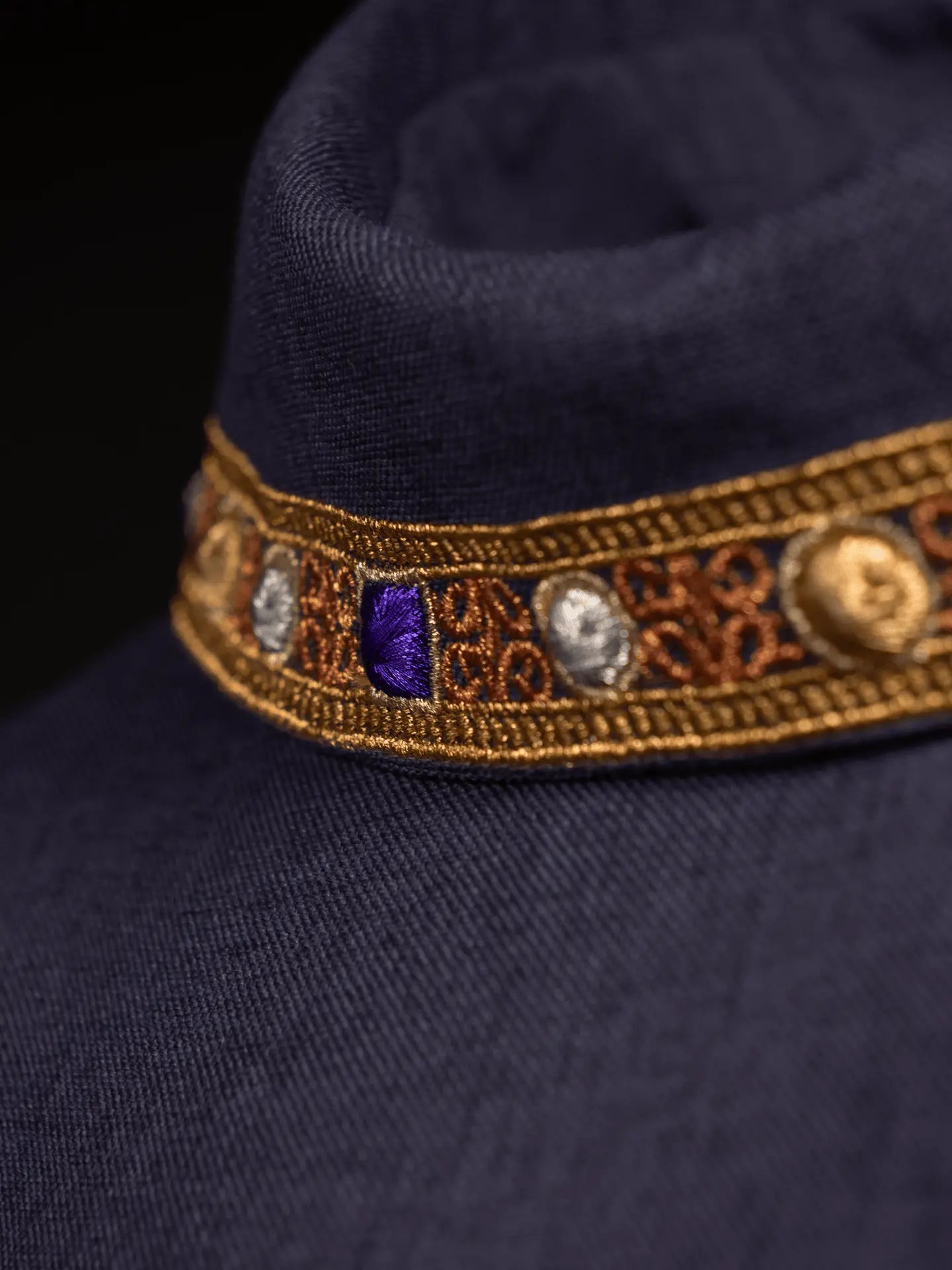 Chasuble violette avec passepoil brodé sur le col et autour de la broderie de la croix