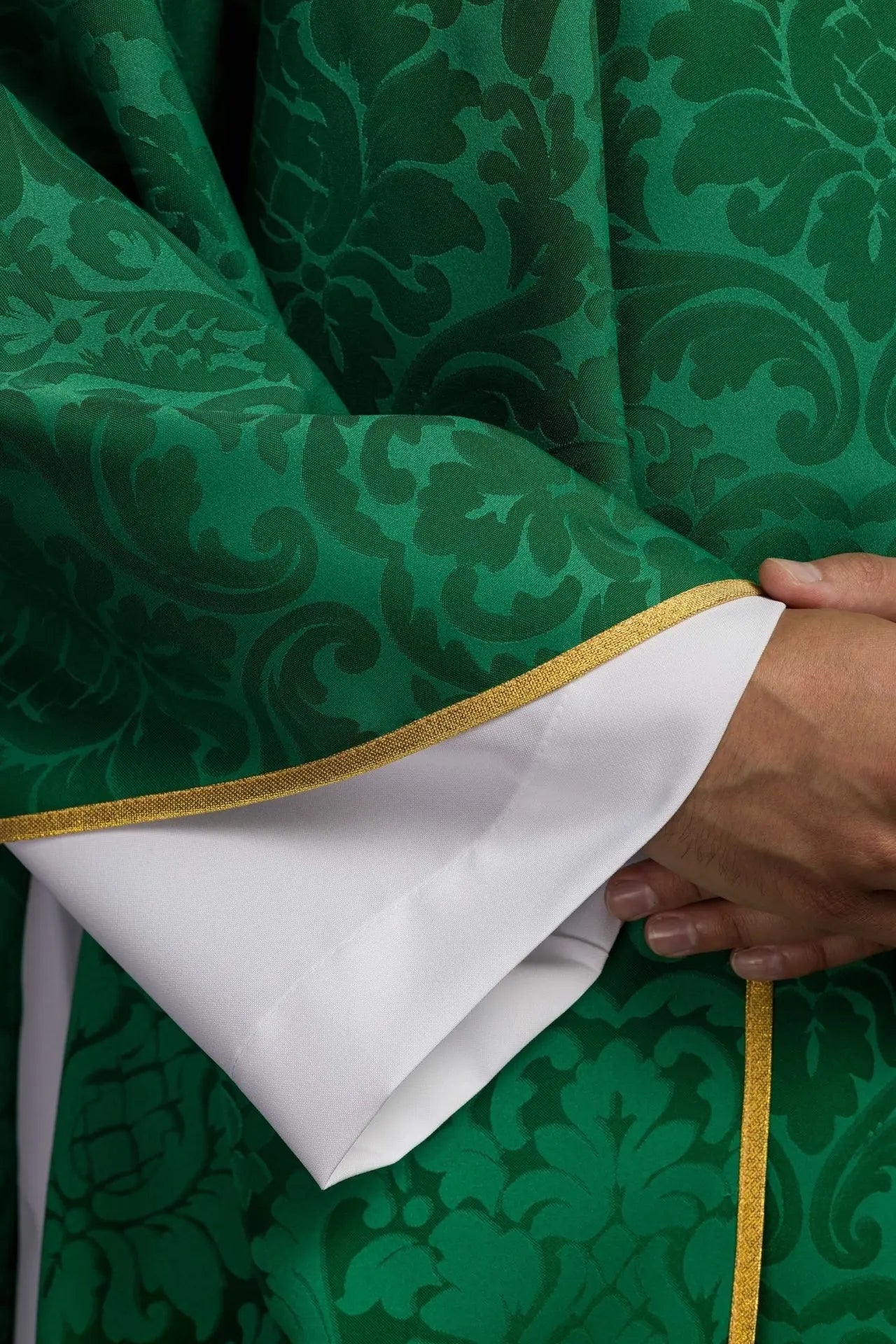 Chasuble verte avec motif IHS et col richement brodé sur tissu décoratif