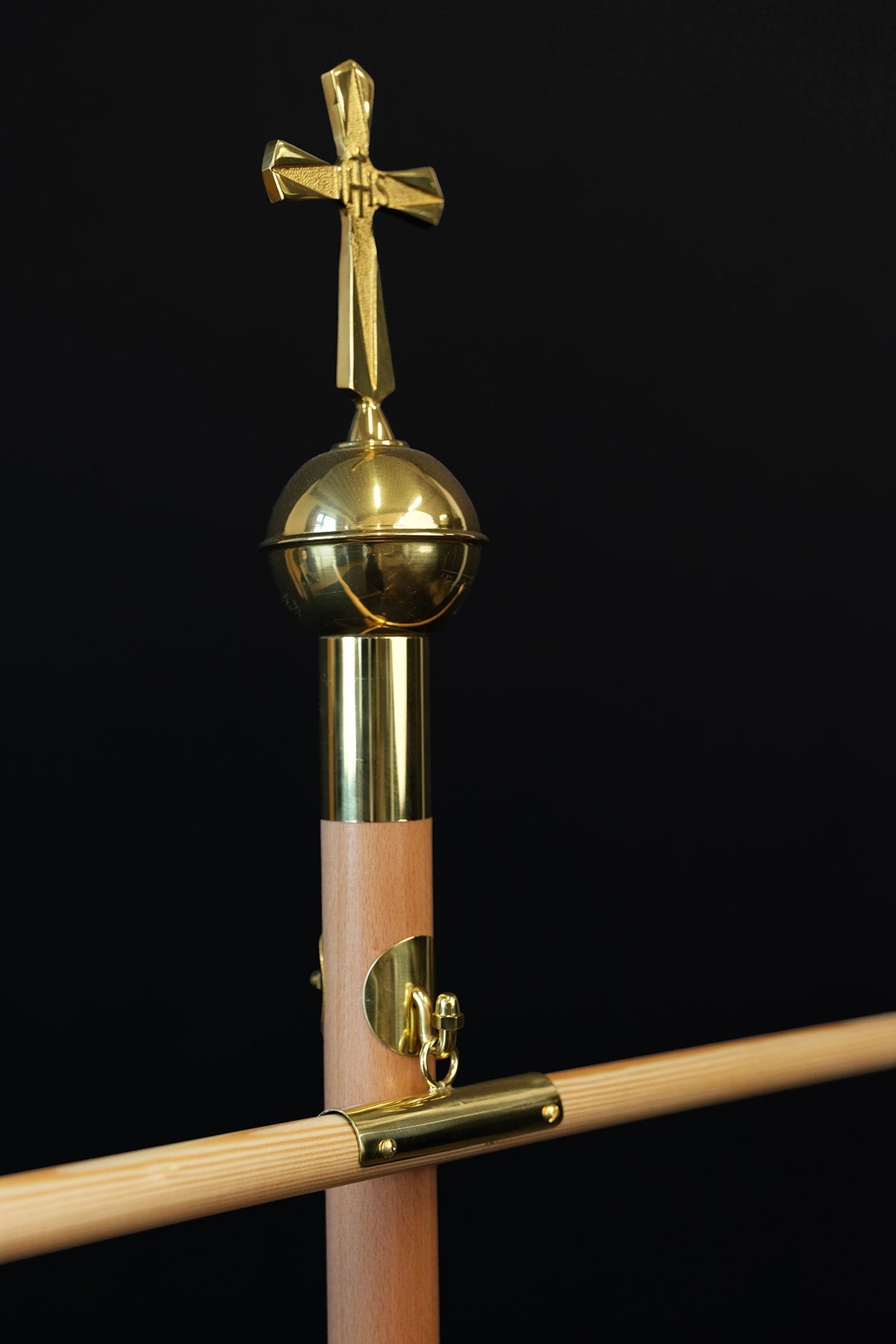 Bois clair hampe de bannière avec croix décorative dorée, gros plan de la croix et de la boule