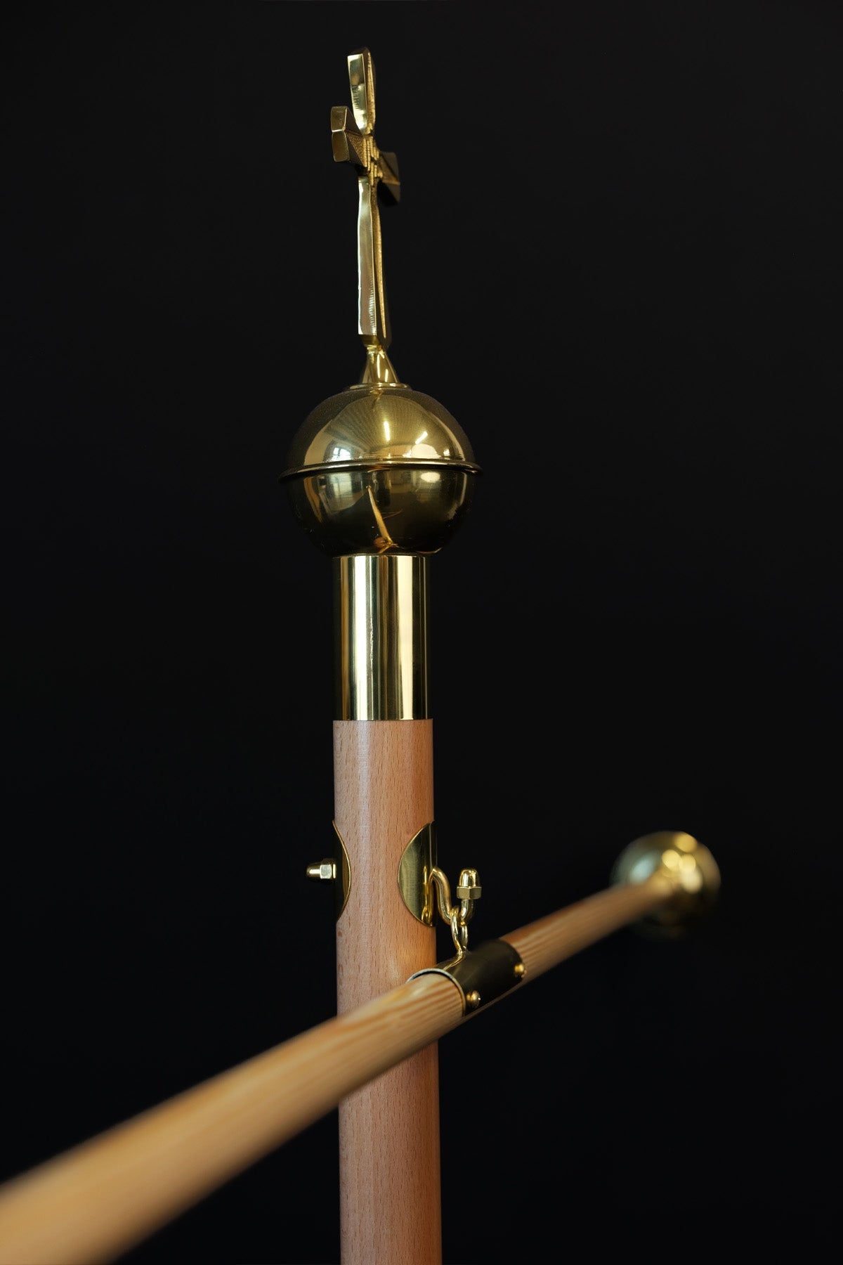 Bois clair hampe de bannière avec croix décorative dorée, détail du crochet et de la fixation